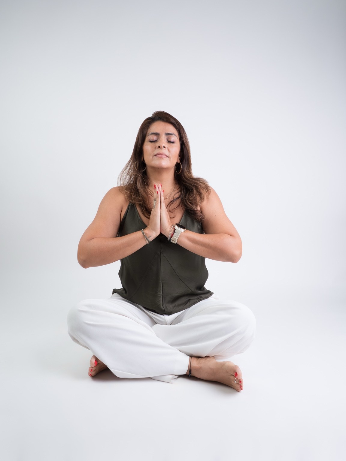 Ale Aguilar meditando sentada con los ojos cerrados y las palmas juntas frente al pecho